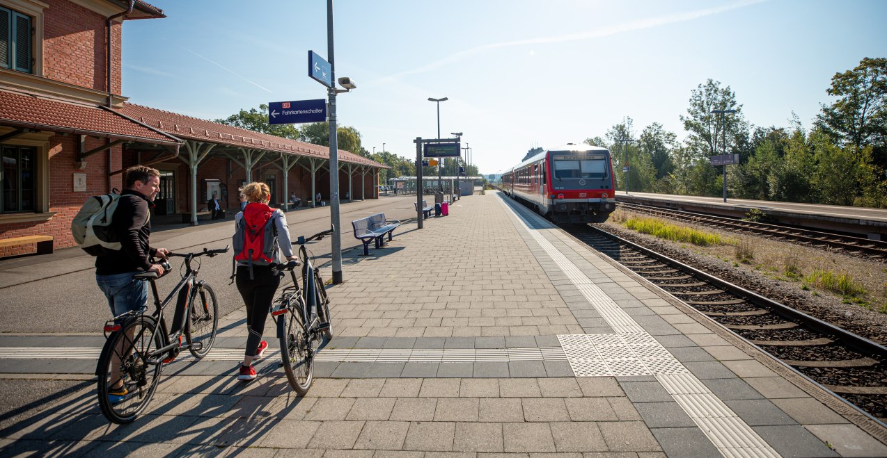 Zwei Radfahrer reisen am Bahnhof Alt&ouml;tting an.
